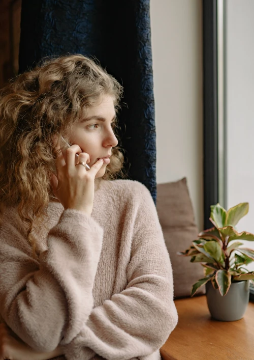 Young girl on the phone and looking out of the window.